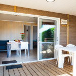 la terrasse et la pièce à vivre du chalet lac par une baie vitrée rétractable